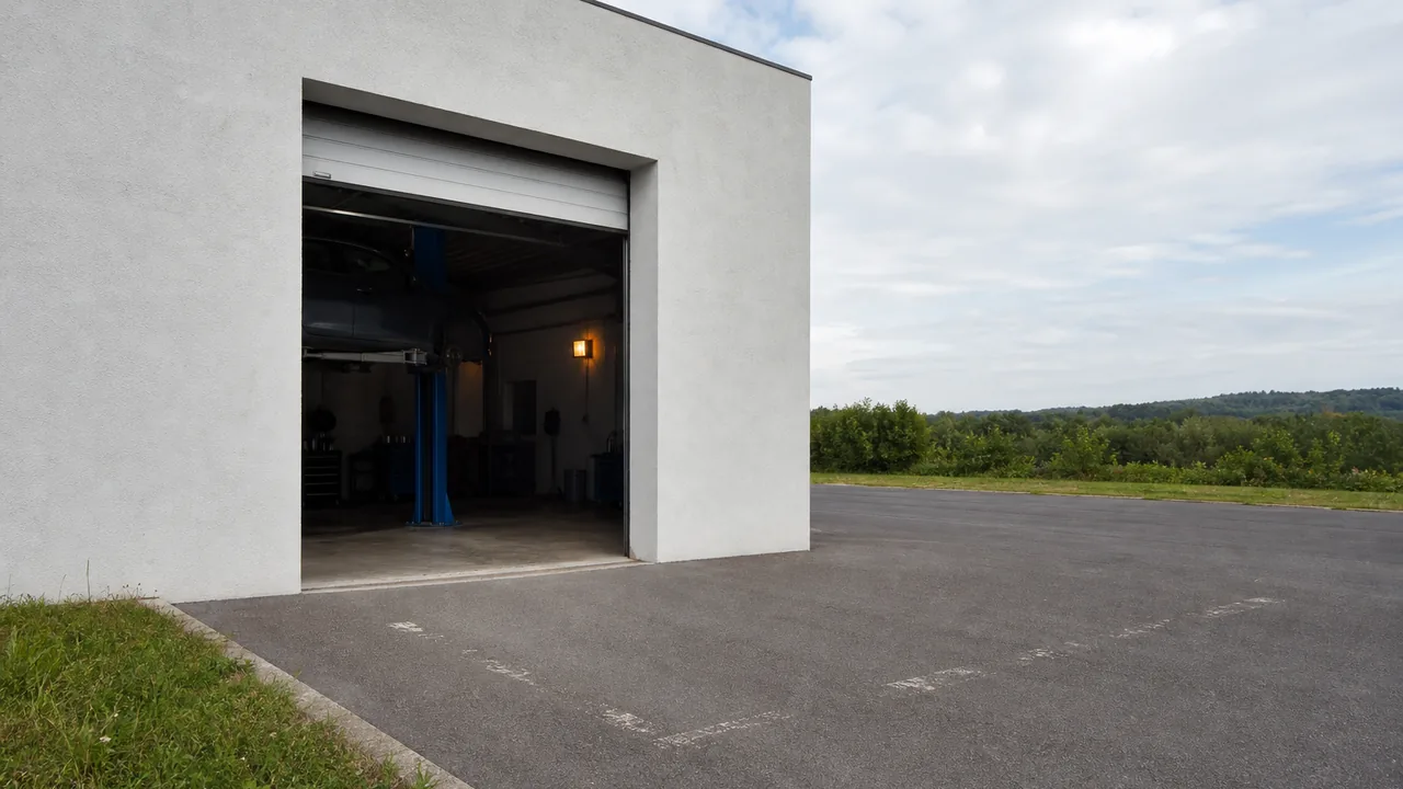 Außenansicht der Werkstatthalle bei Tageslicht mit weit geöffnetem Hallentor